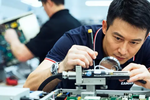 依玛工程师使用放大镜检修喷码设备内部部件