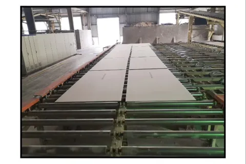 建材车间里板材在输送线上运行的现场实拍，粉尘工况产线