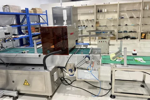 日化包装车间内安装在输送带旁的喷码设备与作业台现场实拍