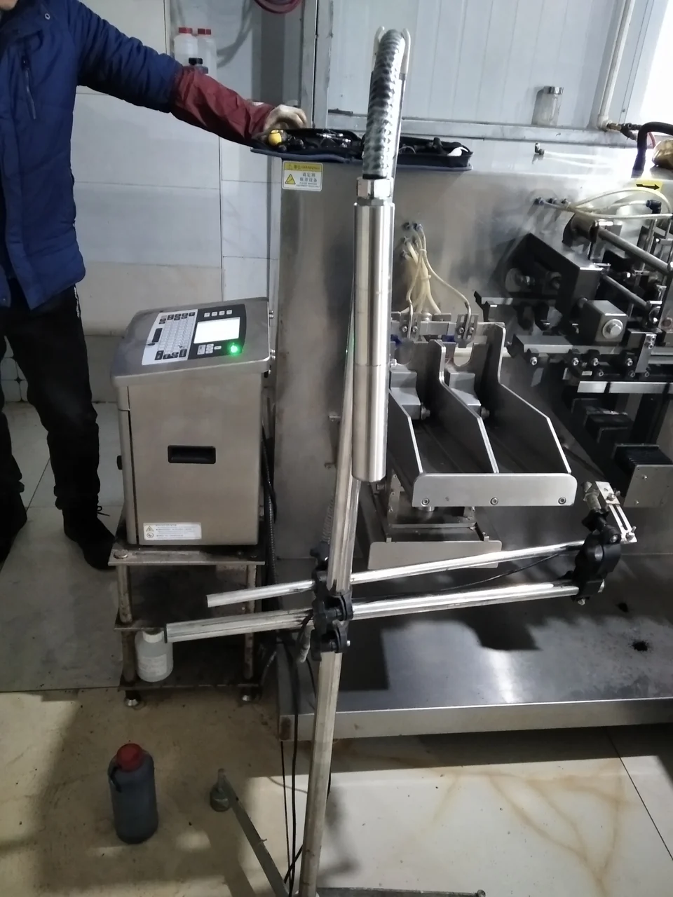 车间里工人正在操作生产线设备,产线停机影响整批货的现场