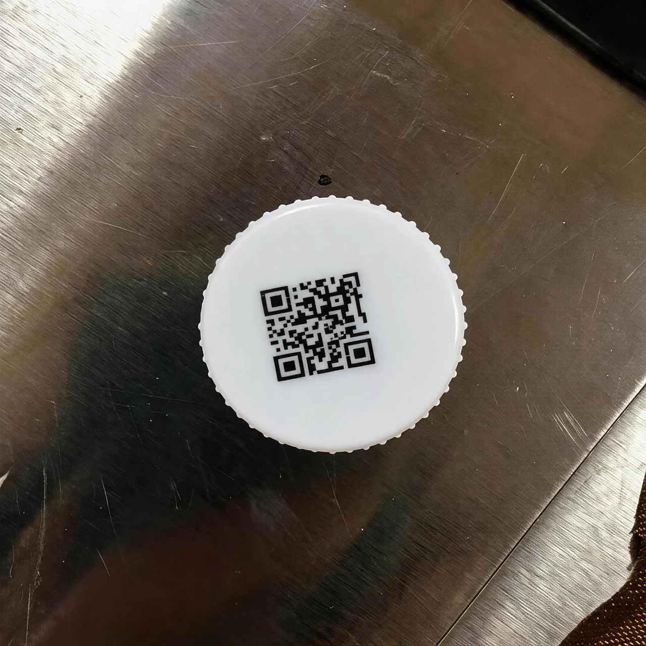 白色圆形瓶盖表面二维码热转印打印效果特写