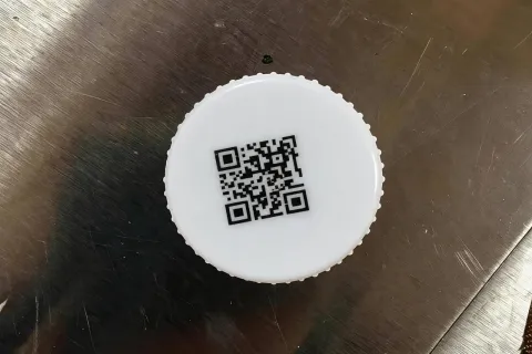 白色圆形瓶盖表面二维码热转印打印效果特写